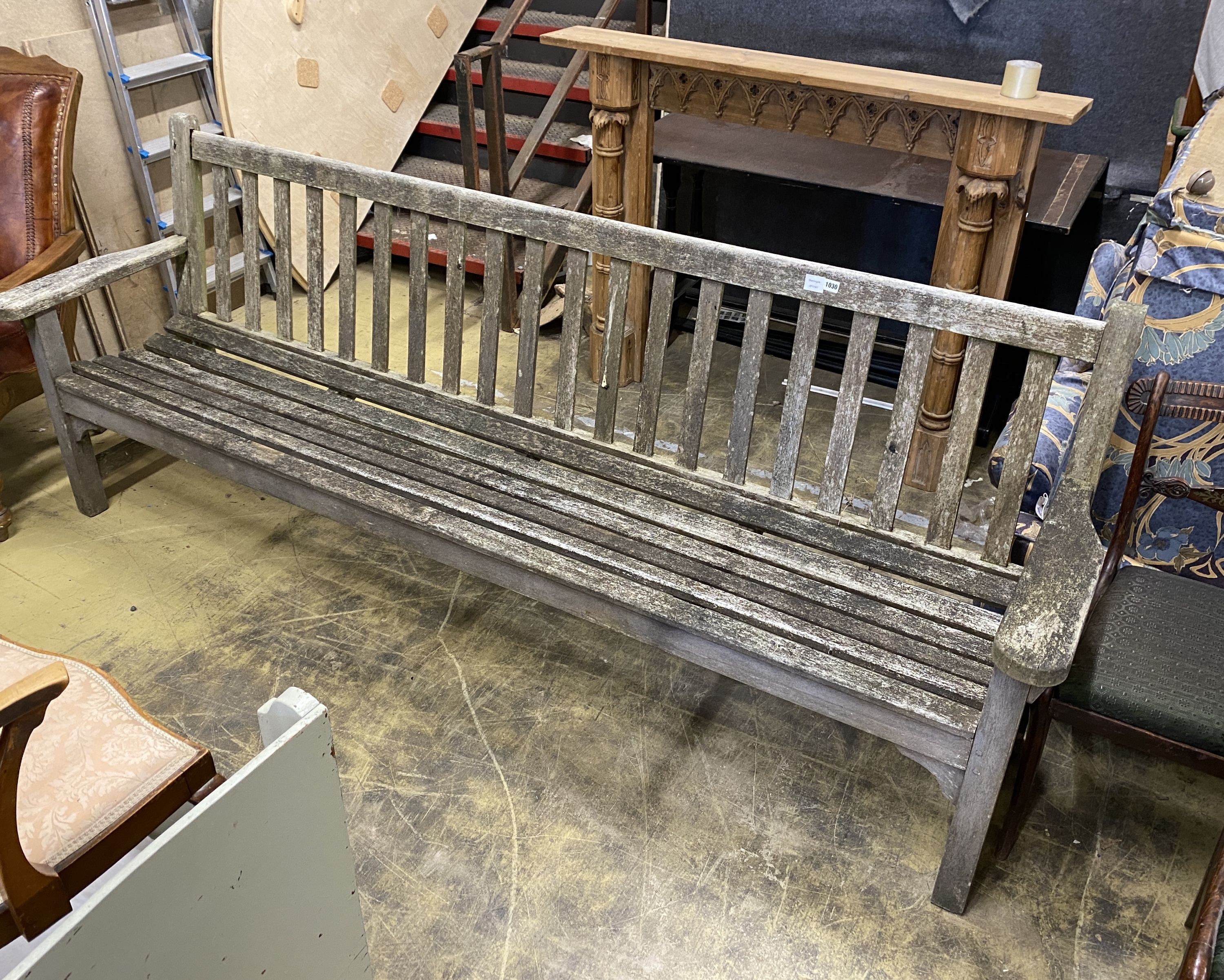 A large weathered teak slatted garden bench, length 254cm, depth 51cm, height 97cm